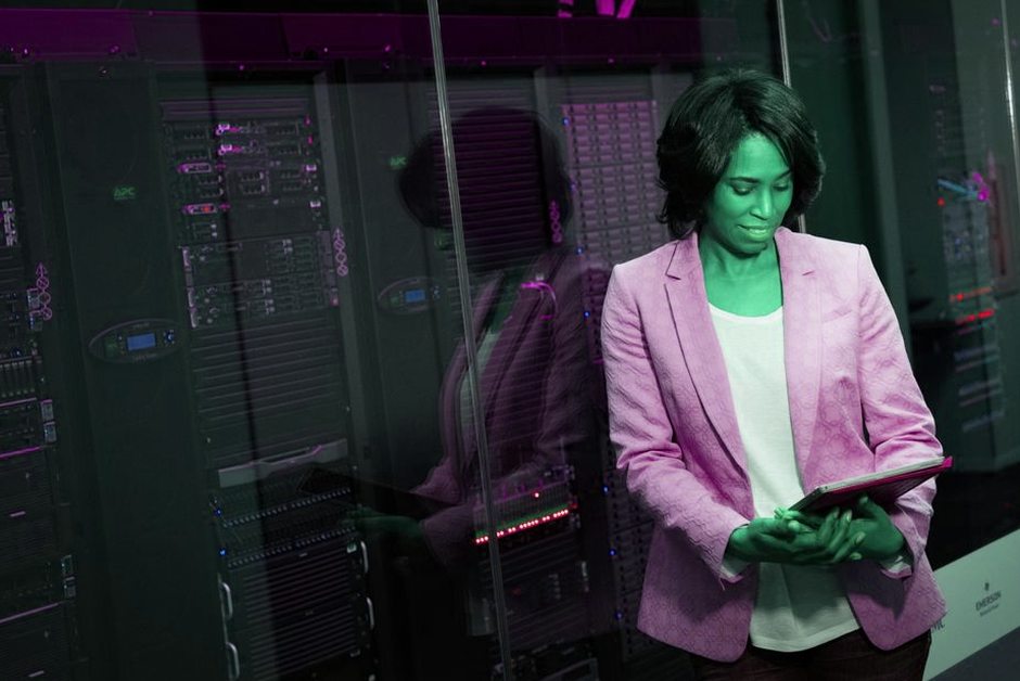 Professionnelle IT inspectant des serveurs dans un datacenter.